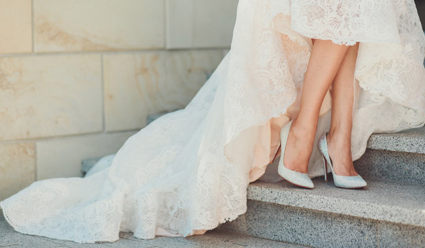 Stylish white wedding shoes standing brides in an elegant dress