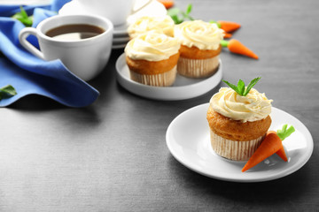 Plate with delicious carrot cupcake on table