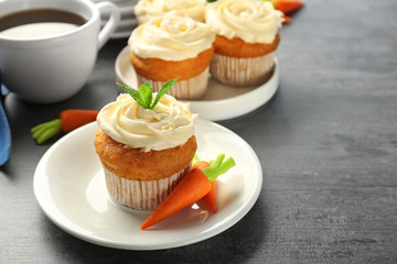 Plate with delicious carrot cupcake on table