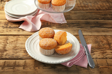 Plate with delicious carrot muffins on table