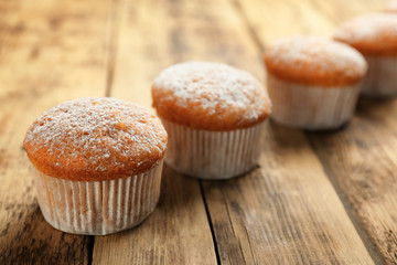 Delicious carrot muffins on wooden background