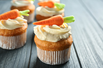 Delicious carrot cupcakes on wooden background