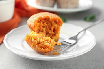 Plate with delicious carrot muffin on table
