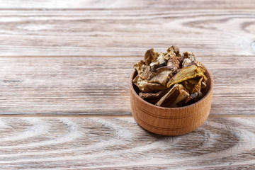 dried mushrooms in a bow , on a wooden table