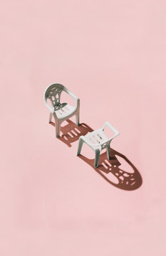 Debate/ 2 chairs facing each other on pink background.