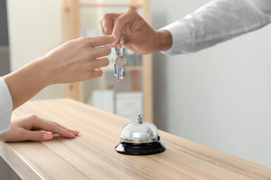 Male receptionist giving key from hotel room to client
