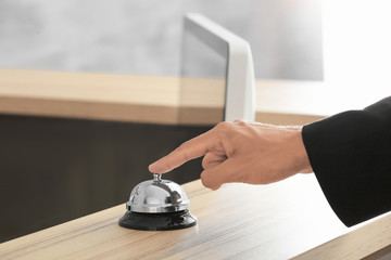 Man ringing service bell at hotel reception