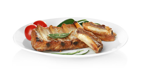 Plate with delicious grilled ribs and garnish isolated on white