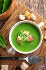 Tureen with delicious spinach soup on wooden table