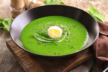 Plate with delicious spinach soup on table
