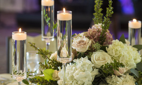 candles floating in stemware and roses for wedding reception