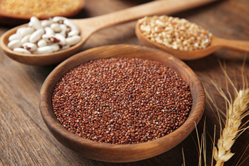 Quinoa seeds in wooden bowl on kitchen table