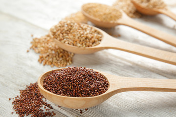 Quinoa seeds in wooden spoon on kitchen table