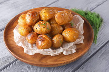 Pile of baked potatoes on wooden tray