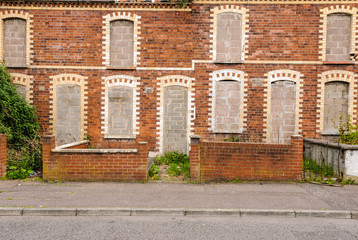 Abandoned houses with bricked up windows and doors in an inner city street in Belfast