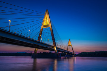 Fototapeta na wymiar Budapest, Hungary - The illuminated Megyeri Bridge over river Danube at blue hour with colorful clear sky