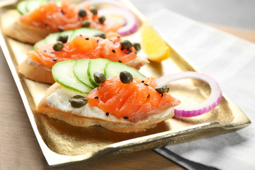 Delicious salmon bruschettas on metal tray, closeup