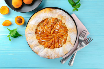 Delicious apricot cake on wooden background