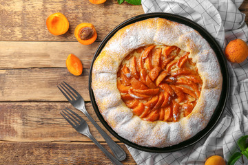 Delicious apricot cake on wooden background