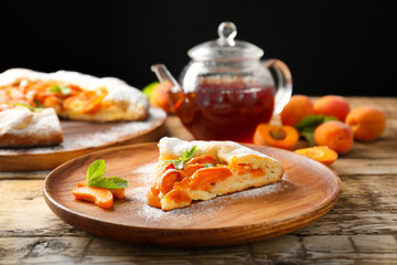 Plate with piece of delicious apricot cake on table