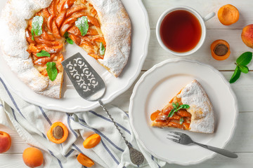 Delicious apricot cake on table