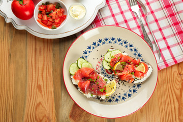 Tasty sandwiches with salmon and lemon on ornate plate