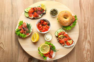 Tasty sandwiches with salmon on wooden board