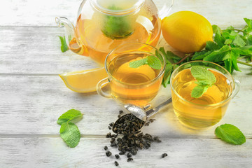 Composition of hot tea with mint leaves on wooden background