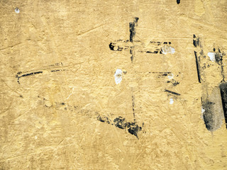 Texture of the plaster. Old yellow wall with graffiti