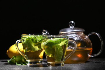 Obraz na płótnie Canvas Cups with tasty mint tea on table