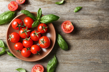 Plate with fresh cherry tomatoes on table