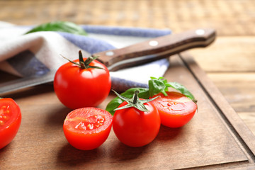 Fresh cherry tomatoes on wooden board, closeup