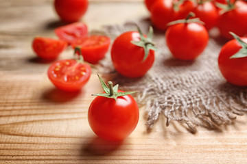 Fresh cherry tomatoes on wooden table, closeup
