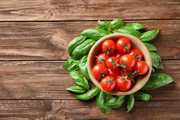 Bowl with fresh cherry tomatoes on wooden table