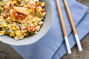 Bowl with brown rice and vegetables on wooden table