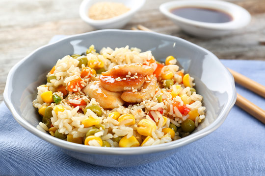 Bowl with brown rice and vegetables on table