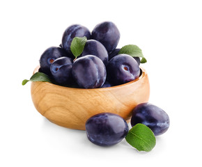 Bowl with ripe plums on white background
