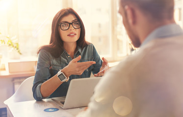 Beautiful female startupper explaining something to business partner