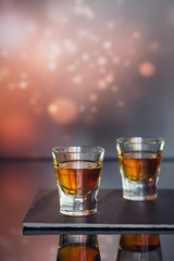 Cognac or liqueur, coffee beans and spices on a glass table.