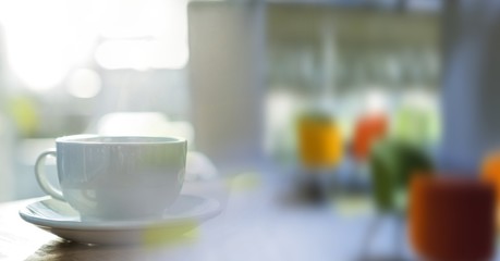 White cup on desk and blurry office transition