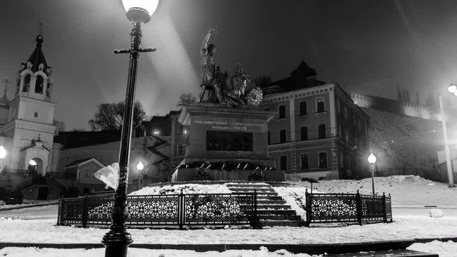 Nizhny Novgorod, Russia. Hyperlapse of Minin and Pozharsky monument near Kremlin at night in Nizhny Novgorod, Russia. Lighted street lamps and snow. Dark sky, time-lapse at night. Black and white