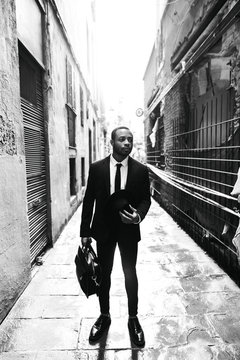 Elegant businessman standing on street of old town.