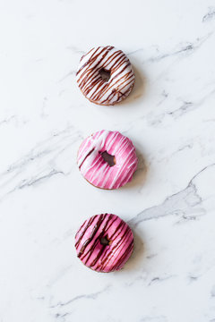 iced donut with striped pattern on a marble background
