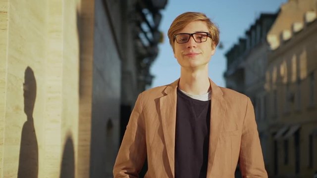 closeup happy smiling boy in beige jacket looking at camera on warm sunny day enjoying moment slow motion 