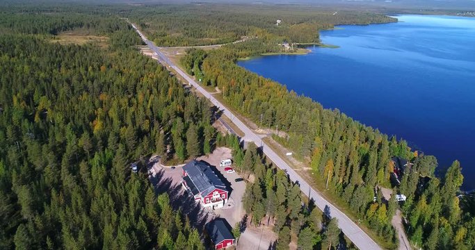 Car on autumn color road, Cinema 4k aerial view  around a car driving between lake pyhajarvi and pyhatunturi, in the arctic taiga wilderess of Lapland, in Lappi, Finland