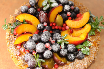 Birthday cake with fruits and berries in a powdered sugar stands on the table. View from above. Idea for the catalog. Idea for the menu