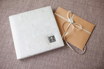 Photo book with a cover of genuine leather. White color with openwork stamping. Soft focus.