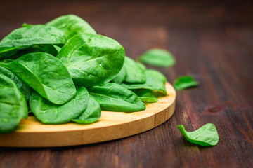 Fresh juicy spinach leaves on a wooden brown table. Natural products, greens, healthy food, vitamins.