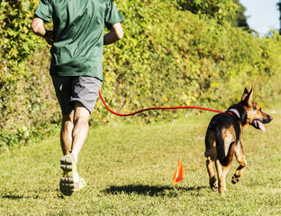 Man running in a park with his dog