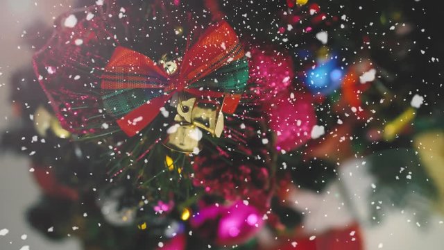 Greeting Season concept.Dolly of ornaments on a Christmas tree with decorative light and falling snow in 4k (UHD)